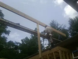 Carpenter setting a ridge beam over a new addition frame — Ice Dam Removal by Roofing Brothers in Holly Hill