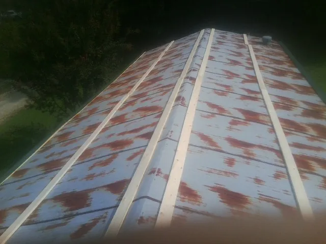 Rusted metal roof panels with new wood purlins before replacement — Storm Damage Roof Repair in Holly Hill by Roofing Brothers