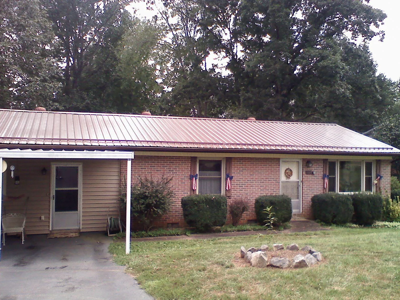 Bronze metal roof and carport on a brick ranch home — Roof Repair work by our crew in Holly Hill