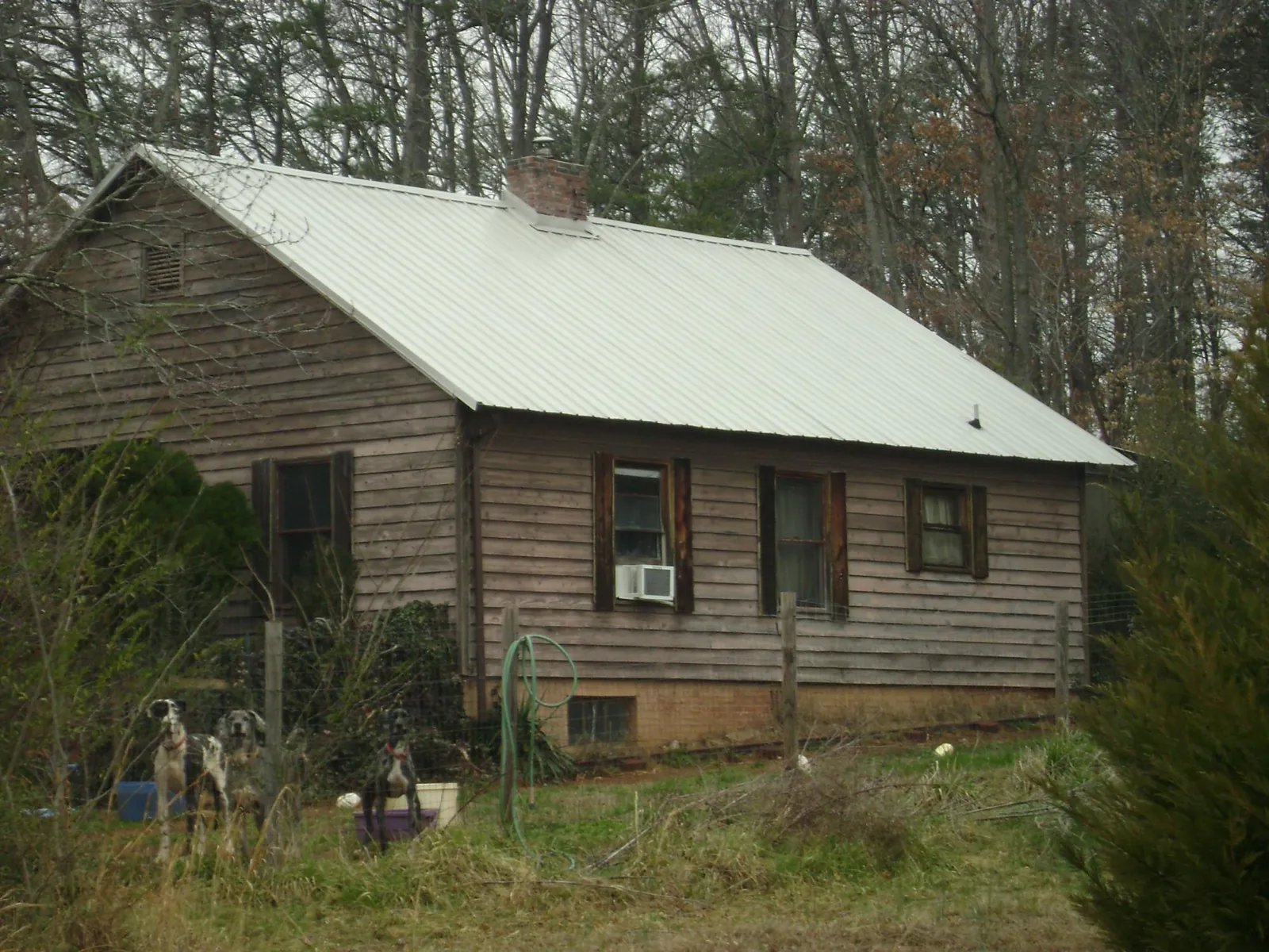 White metal roof on an old wood sided farmhouse, from a Metal Roof Installation job in Holly Hill